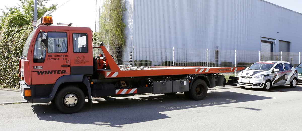 Abschleppwagen von KFZ Winter vor der Werkstatt in Ehningen, dahinter das Ersatzfahrzeug für Kundinnen und Kunden während der Reparatur.