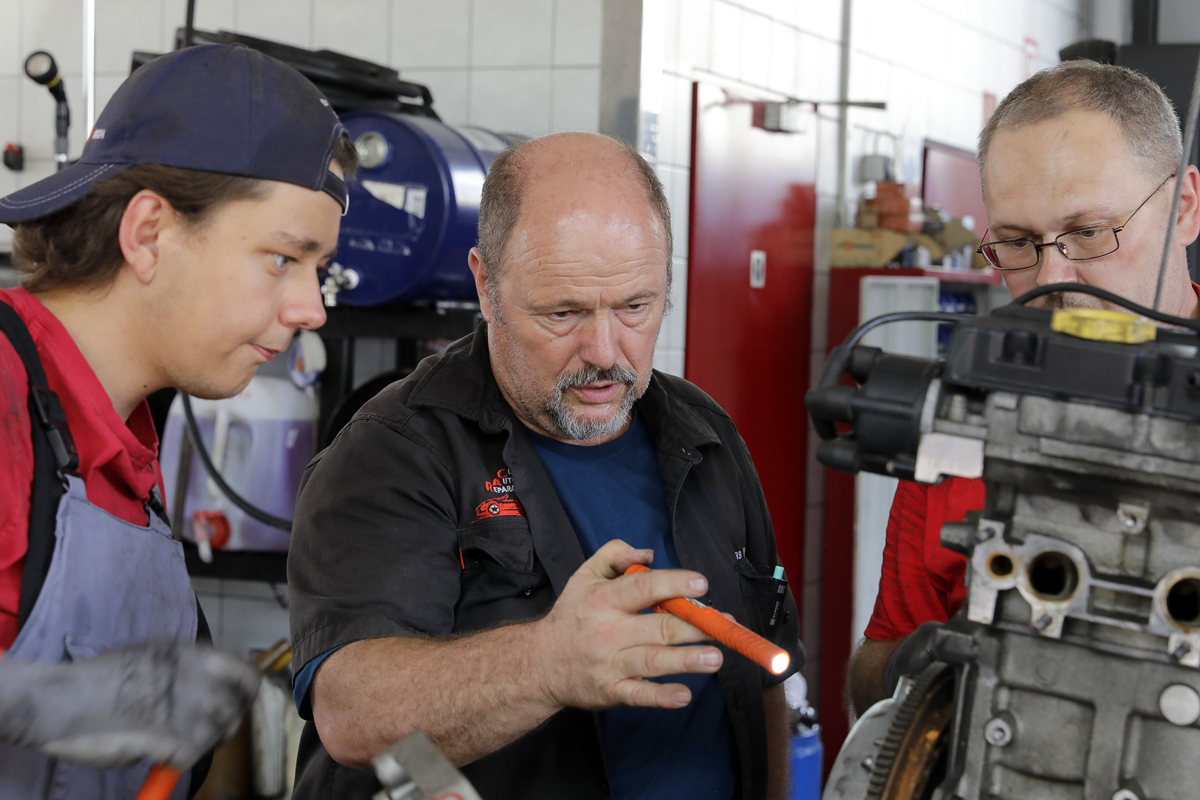 Andreas Winter prüft gemeinsam mit dem Werkstattteam einen ausgebauten Motor.